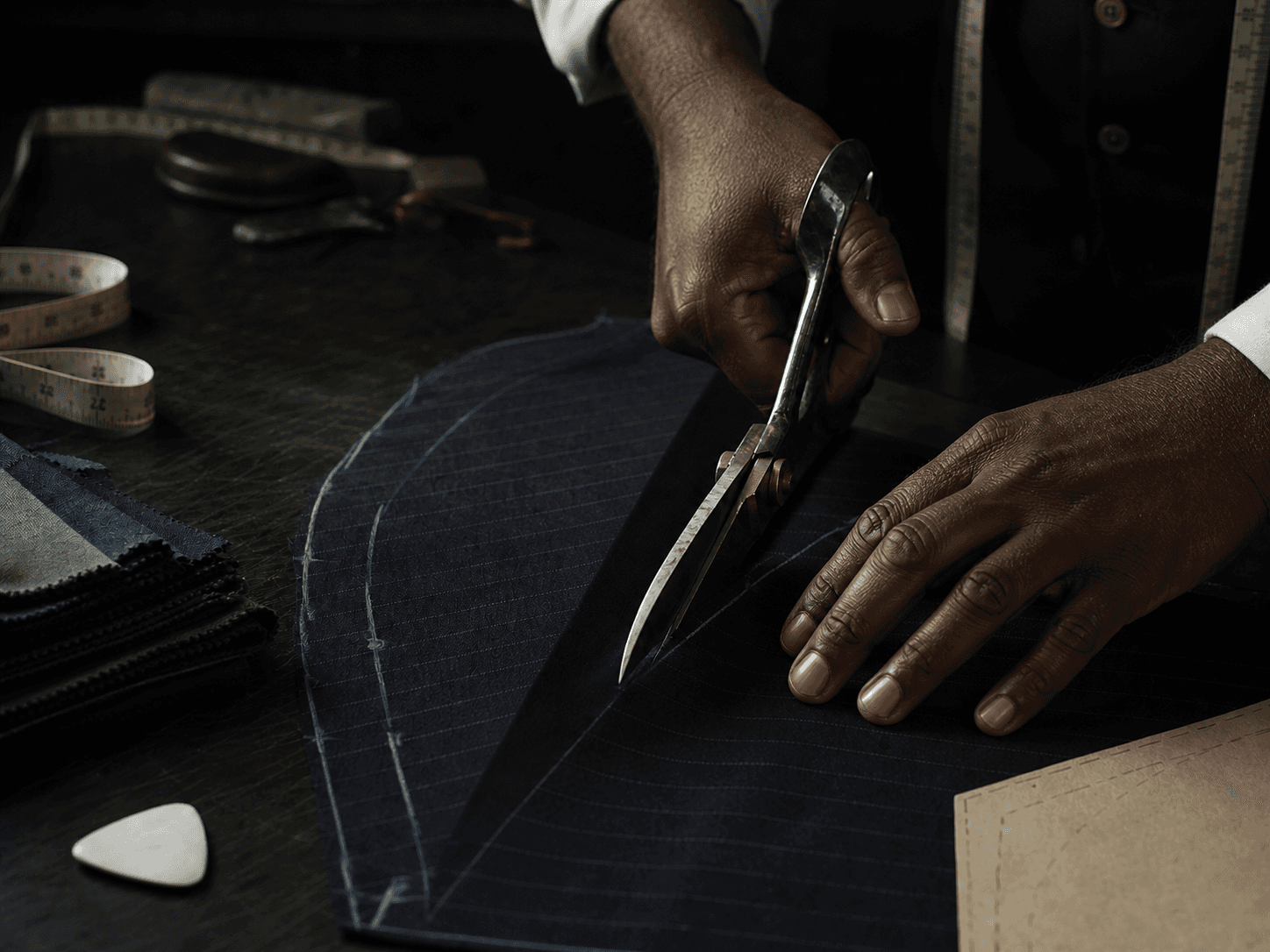 Tailor cutting navy wool by hand